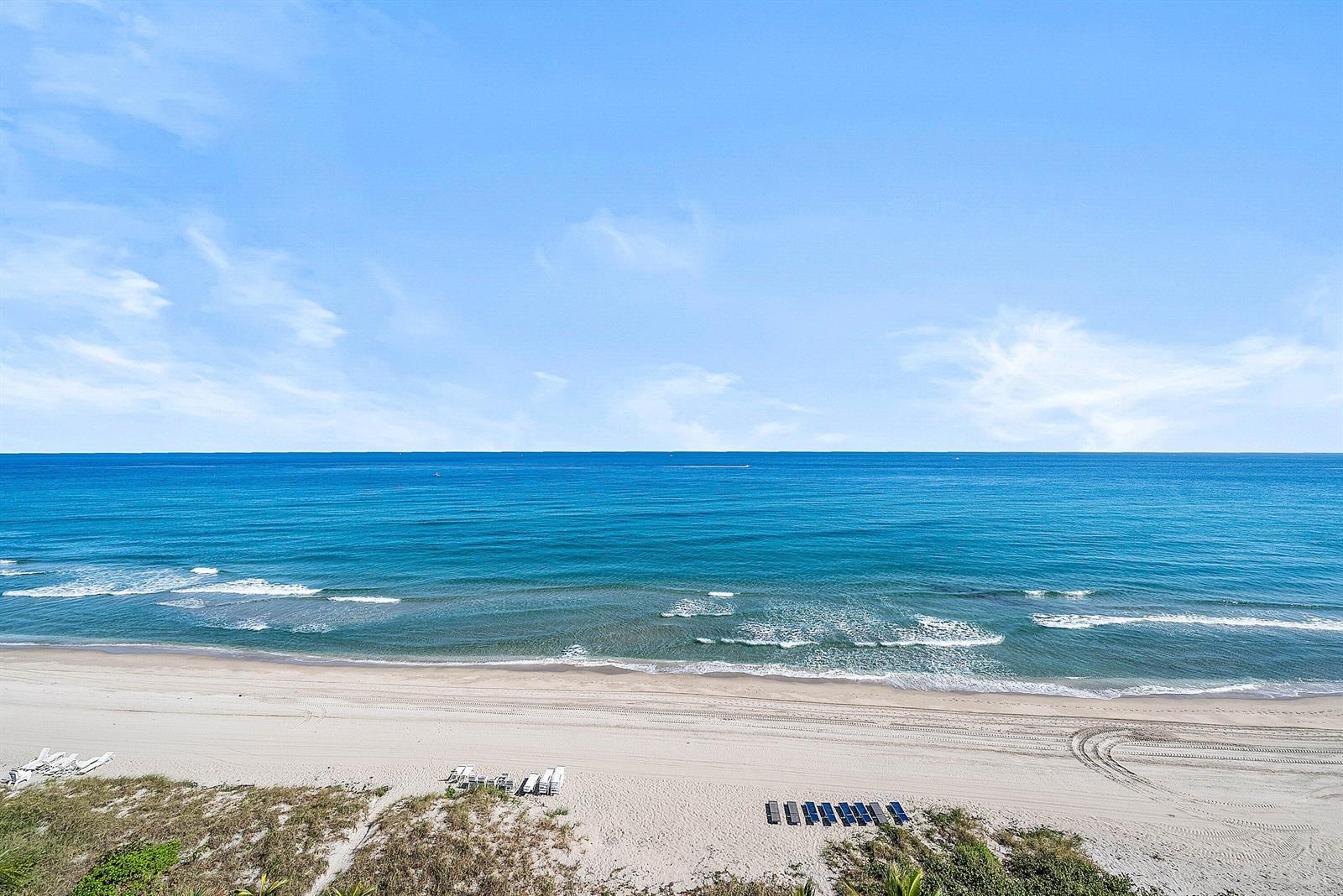 An elevated view of a sandy beach with lounge chairs overlooking the blue ocean — 2066 N Ocean Boulevard, Boca Raton FL 33431, BOCA RATON, FL