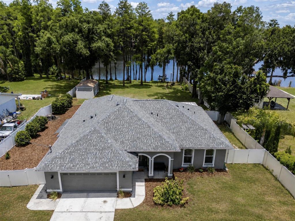An aerial view of a gray single-story house with a shingled roof and a backyard — 219 WILLOW BEND PARKWAY, LUTZ, FL