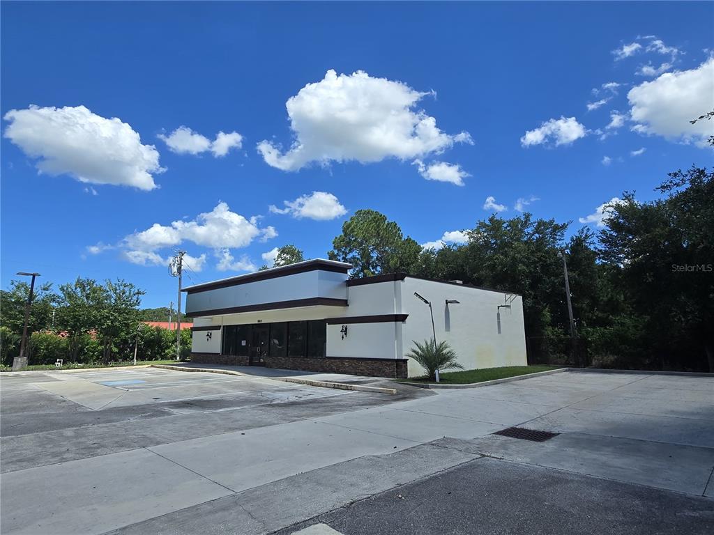 A single-story commercial building with a white facade and dark trim sits on a lot — 8801 20TH STREET, VERO BEACH, FL