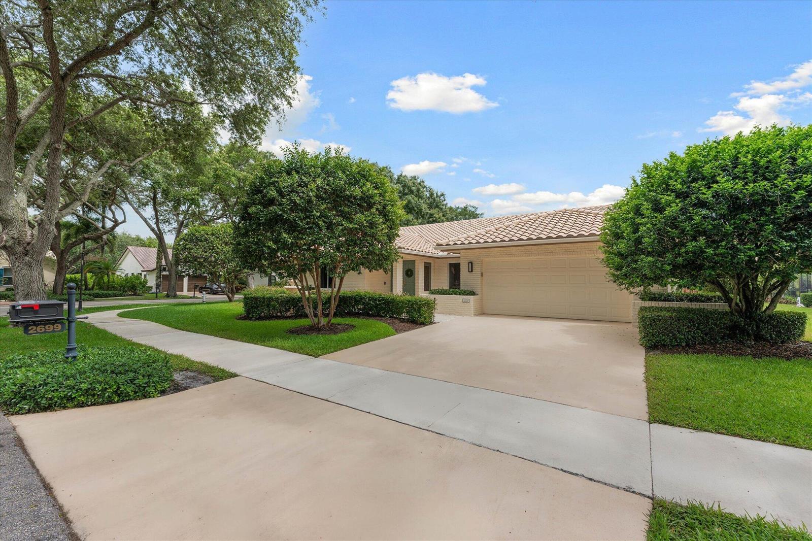 A single-story house with a beige tile roof, two-car garage, and a manicured front lawn — 2699 NW 38th Street, Boca Raton FL 33434, BOCA RATON, FL