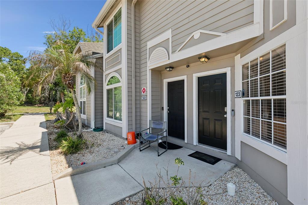 The exterior of a two-story residential building features two black front doors and a walkway — 505 SUN RIDGE PLACE UNIT 123, ALTAMONTE SPRINGS, FL