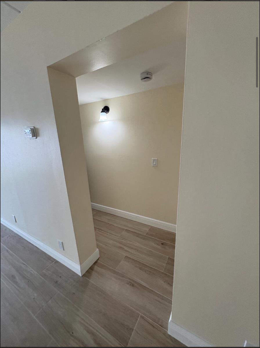 A view through a doorway into a small room featuring light-colored walls and wood-look flooring — 1501 Crescent Circle # E39, Lake Park FL 33403, LAKE PARK, FL