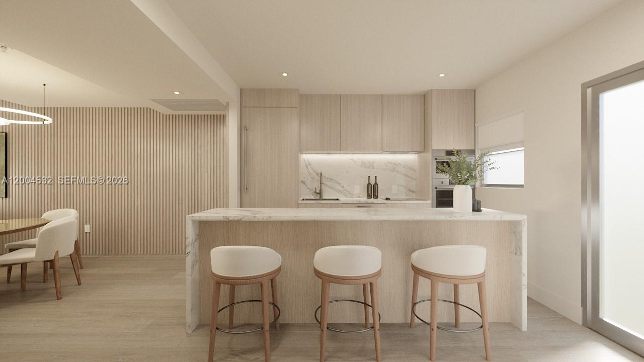 This rendering shows a modern kitchen with light wood cabinetry, marble countertops, and bar seating — 250 Collins Ave # 109, Miami Beach FL 33139, MIAMI BEACH, FL