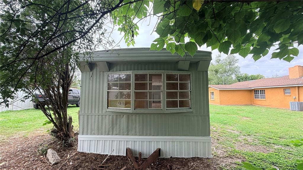 A light green mobile home exterior features a large bay window and a metal hitch — 115 WHITFIELD STREET, MULBERRY, FL