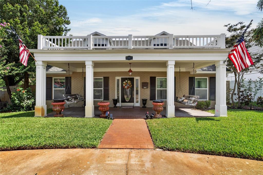 A single-story brick house features a large front porch with white columns and two swings — 4121 W DE LEON STREET, TAMPA, FL