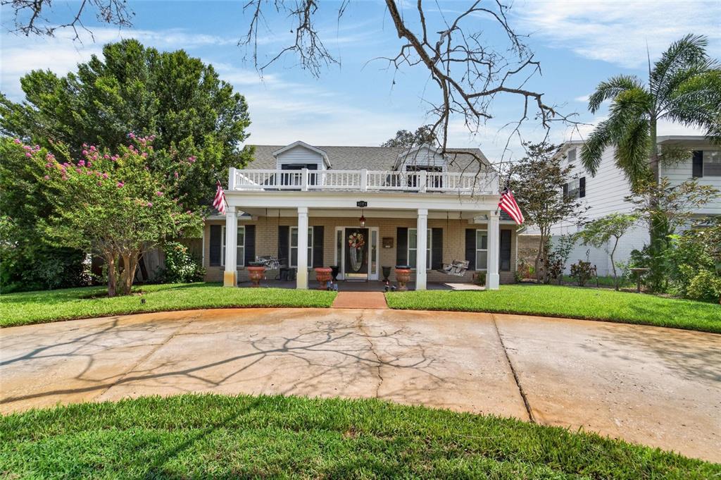 A two-story brick house features a large front porch with a balcony above — 4121 W DE LEON STREET, TAMPA, FL
