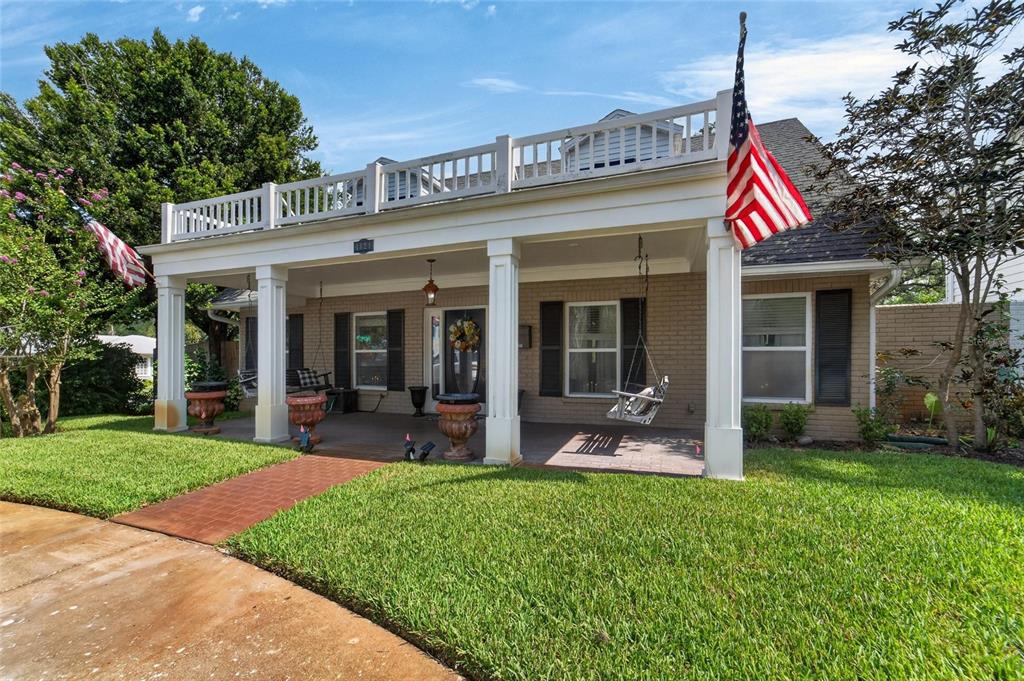 A brick house features a large covered front porch with white columns and a balcony — 4121 W DE LEON STREET, TAMPA, FL
