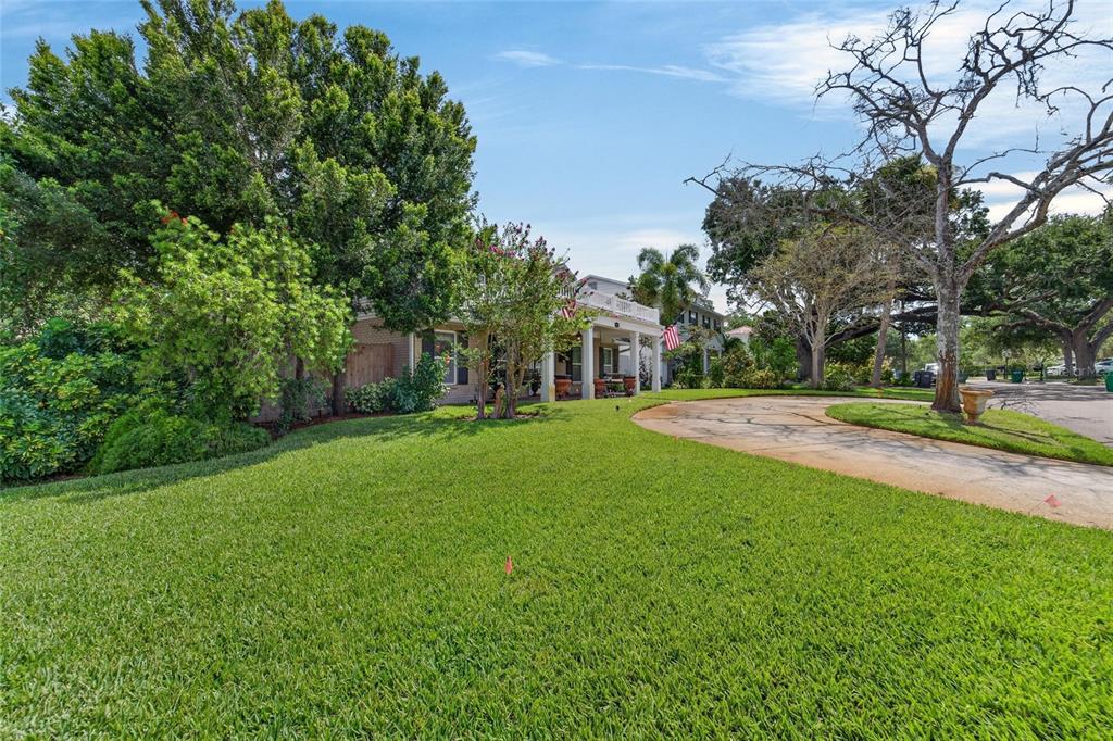 A two-story house with a white porch and a curved driveway sits on a lawn — 4121 W DE LEON STREET, TAMPA, FL