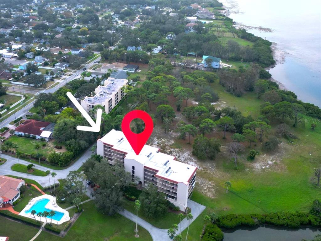 An aerial view shows a multi-story apartment building near a body of water — 504 S FLORIDA AVENUE UNIT 235, TARPON SPRINGS, FL