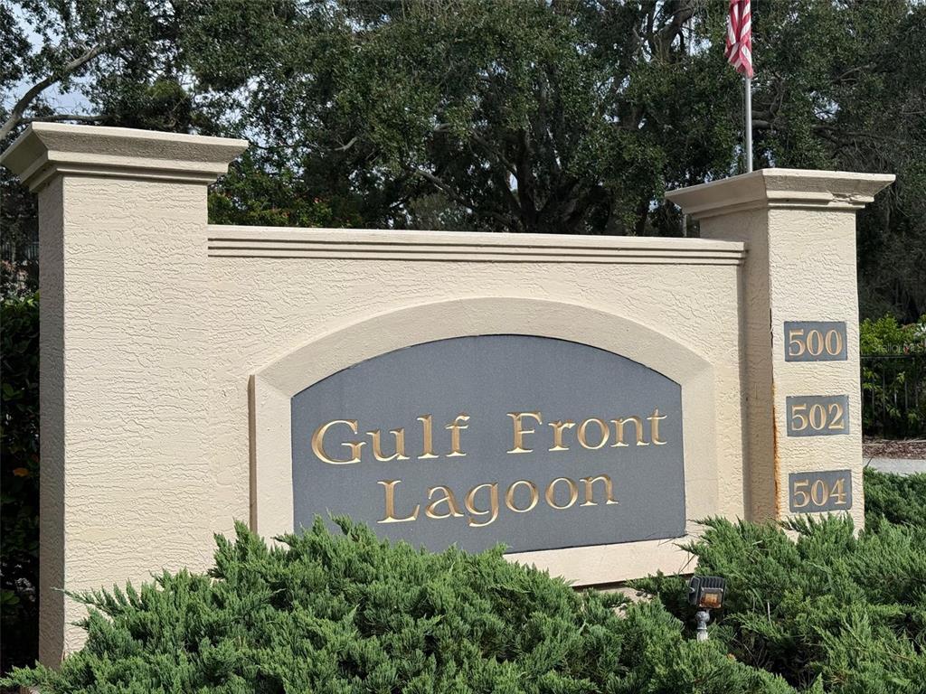 A beige stucco monument sign for Gulf Front Lagoon sits behind green landscaping — 504 S FLORIDA AVENUE UNIT 235, TARPON SPRINGS, FL