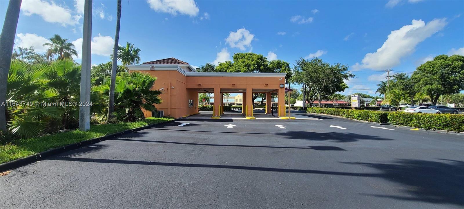 A commercial building features a drive-thru lane with multiple service bays and surrounding landscaping — 5300 Coconut Creek Pkwy, Margate FL 33063, MARGATE, FL