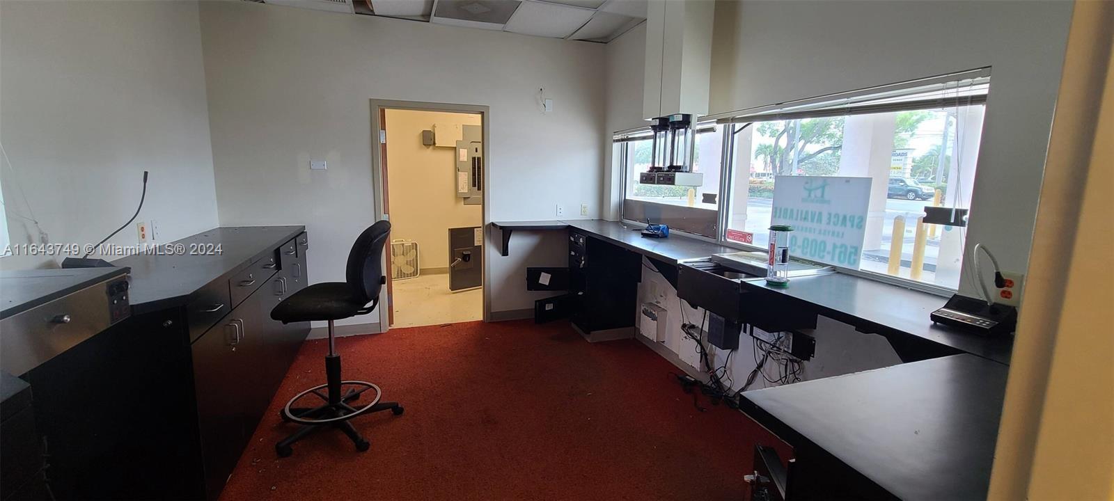 An office space features dark countertops, a rolling chair, red carpeting, and a large window — 5300 Coconut Creek Pkwy, Margate FL 33063, MARGATE, FL