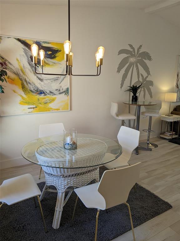 A dining area features a glass-topped wicker table, modern white chairs, and a palm tree decal — 1414 58TH STREET W, BRADENTON, FL
