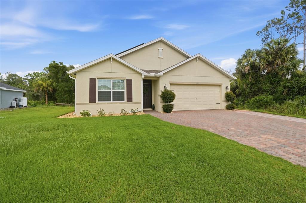 A single-story house with a beige stucco exterior, a two-car garage, and a paved driveway — 1782 YANKEE TERRACE, NORTH PORT, FL