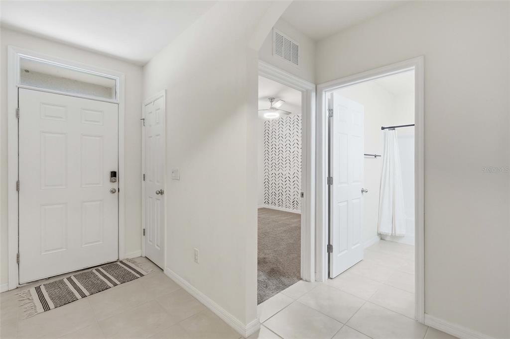 An entryway features a white front door, tiled floors, and doorways leading to other rooms — 1782 YANKEE TERRACE, NORTH PORT, FL