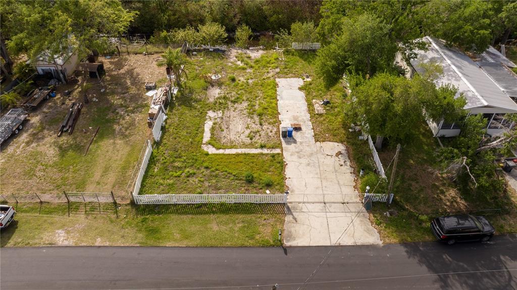 An aerial view shows a vacant residential lot with a concrete driveway and foundation slab — 9923 ALAVISTA DRIVE, GIBSONTON, FL