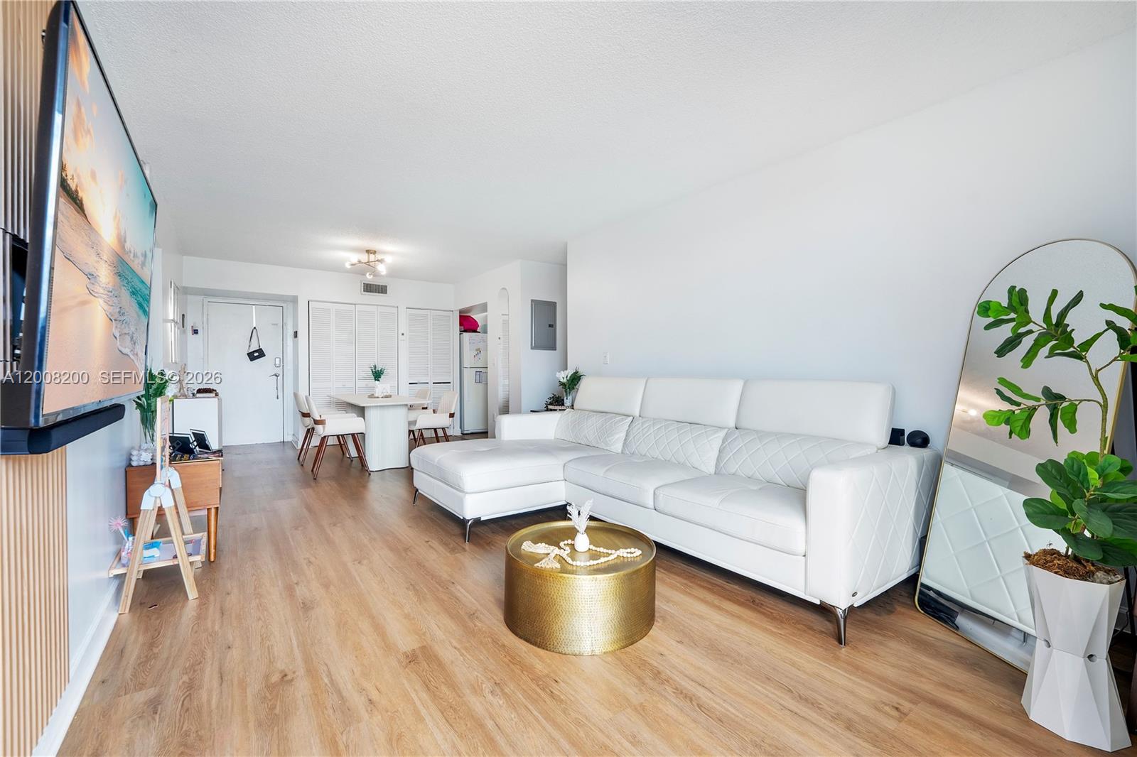 A living room features a white sectional sofa, a gold coffee table, and wood flooring — 8261 NW 8th St # 231, Miami FL 33126, MIAMI, FL