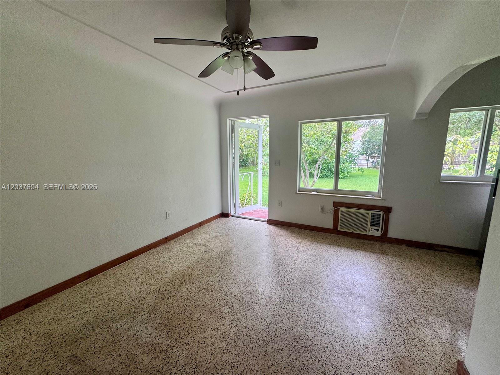 A room with a ceiling fan, terrazzo flooring, a window air conditioner, and an exterior door — 8440 NE 1st Ave # 2, Miami FL 33138, MIAMI, FL
