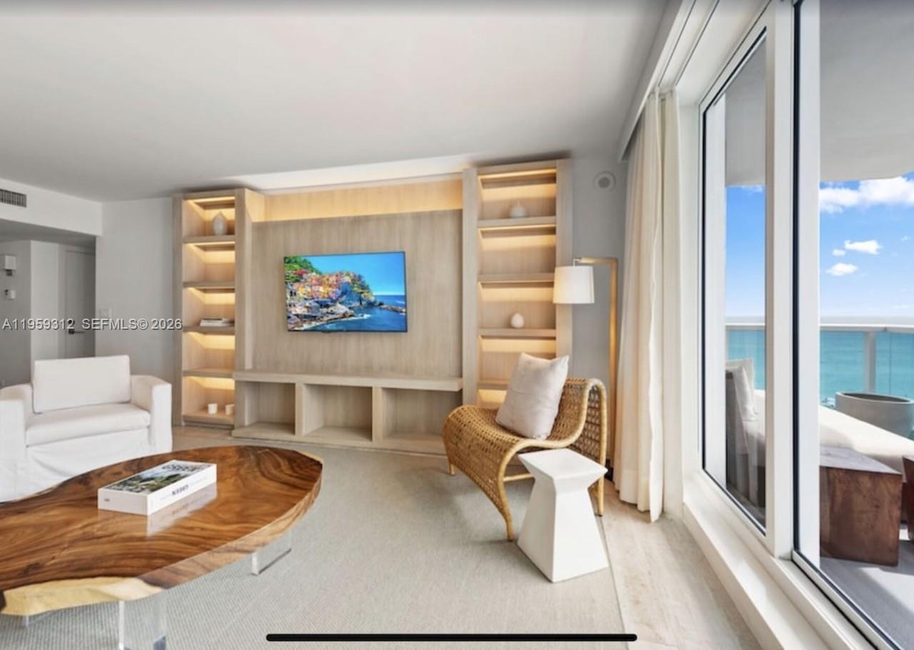 A bedroom features a king-sized bed, a desk with a woven chair, and neutral decor — 102 24th St # 1206, Miami Beach FL 33139, MIAMI BEACH, FL