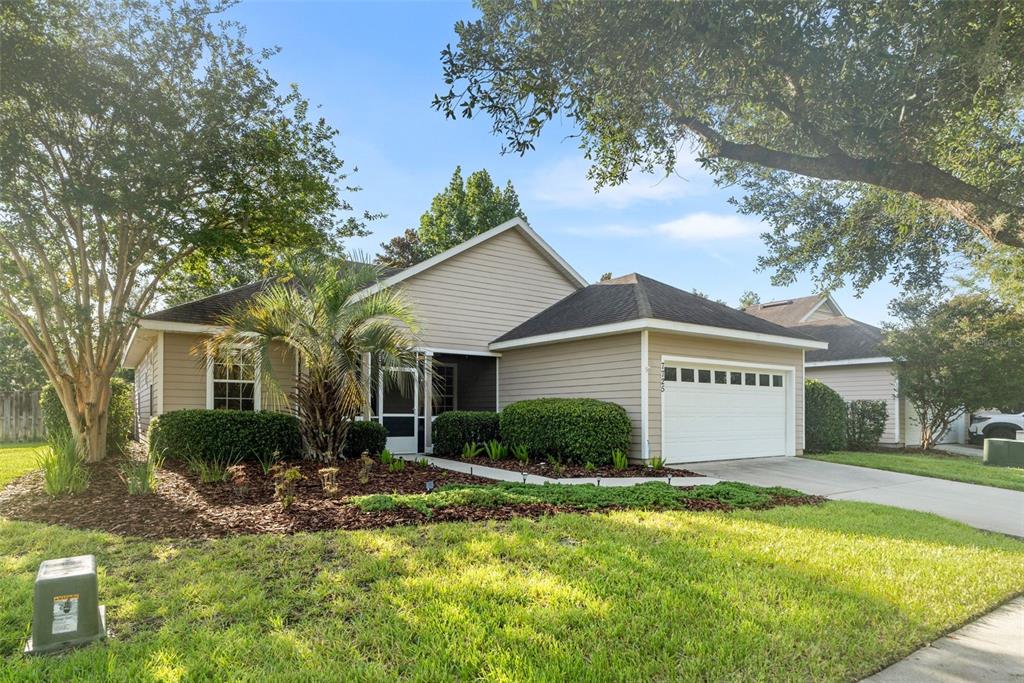 A single-story house with beige siding, a two-car garage, and a landscaped front yard — 7725 SW 87TH TERRACE, GAINESVILLE, FL