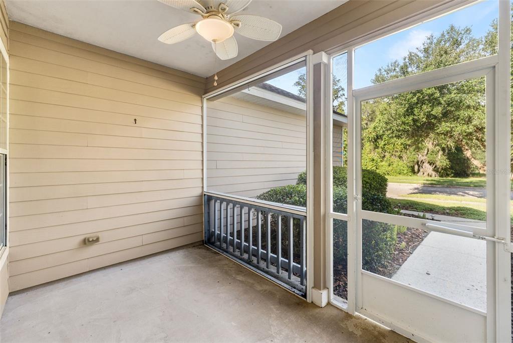 A screened-in porch with beige siding, a ceiling fan, and a concrete floor — 7725 SW 87TH TERRACE, GAINESVILLE, FL