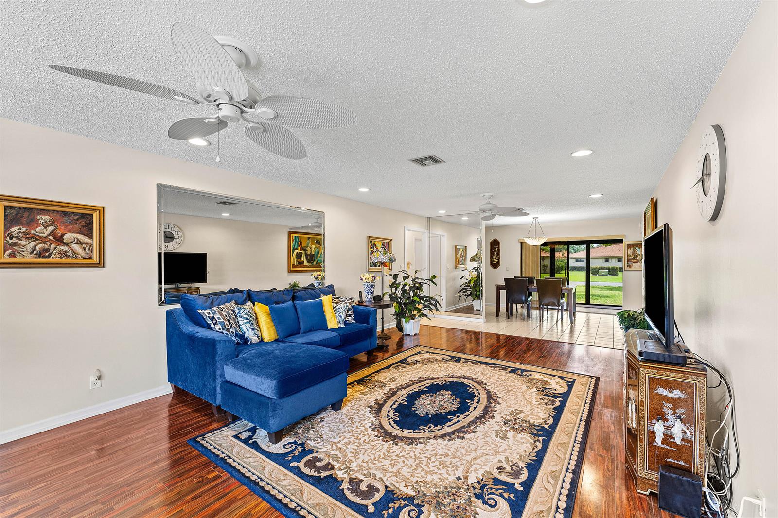 A living room features a blue sectional sofa, a patterned area rug, and hardwood floors — 4520 Ficus Tree Road, Boynton Beach FL 33436, BOYNTON BEACH, FL
