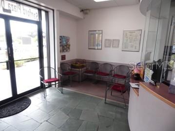 A waiting room features a glass door, tile flooring, and several chairs arranged against the wall — 2921 S ORLANDO DRIVE UNIT 146, SANFORD, FL