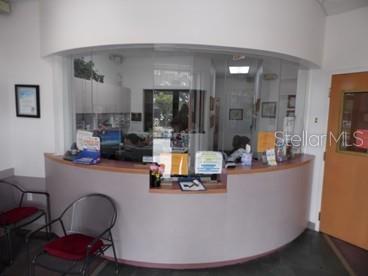 A reception area features a curved desk with a glass partition and two chairs — 2921 S ORLANDO DRIVE UNIT 146, SANFORD, FL