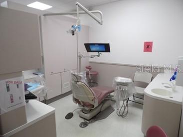 A dental examination room features a patient chair, dental equipment, a monitor, and cabinetry — 2921 S ORLANDO DRIVE UNIT 146, SANFORD, FL