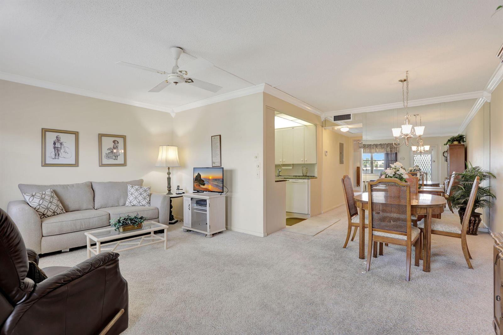 A living room and dining area with beige carpet, neutral walls, and a ceiling fan — 432 Grantham # B, Deerfield Beach FL 33442, DEERFIELD BEACH, FL