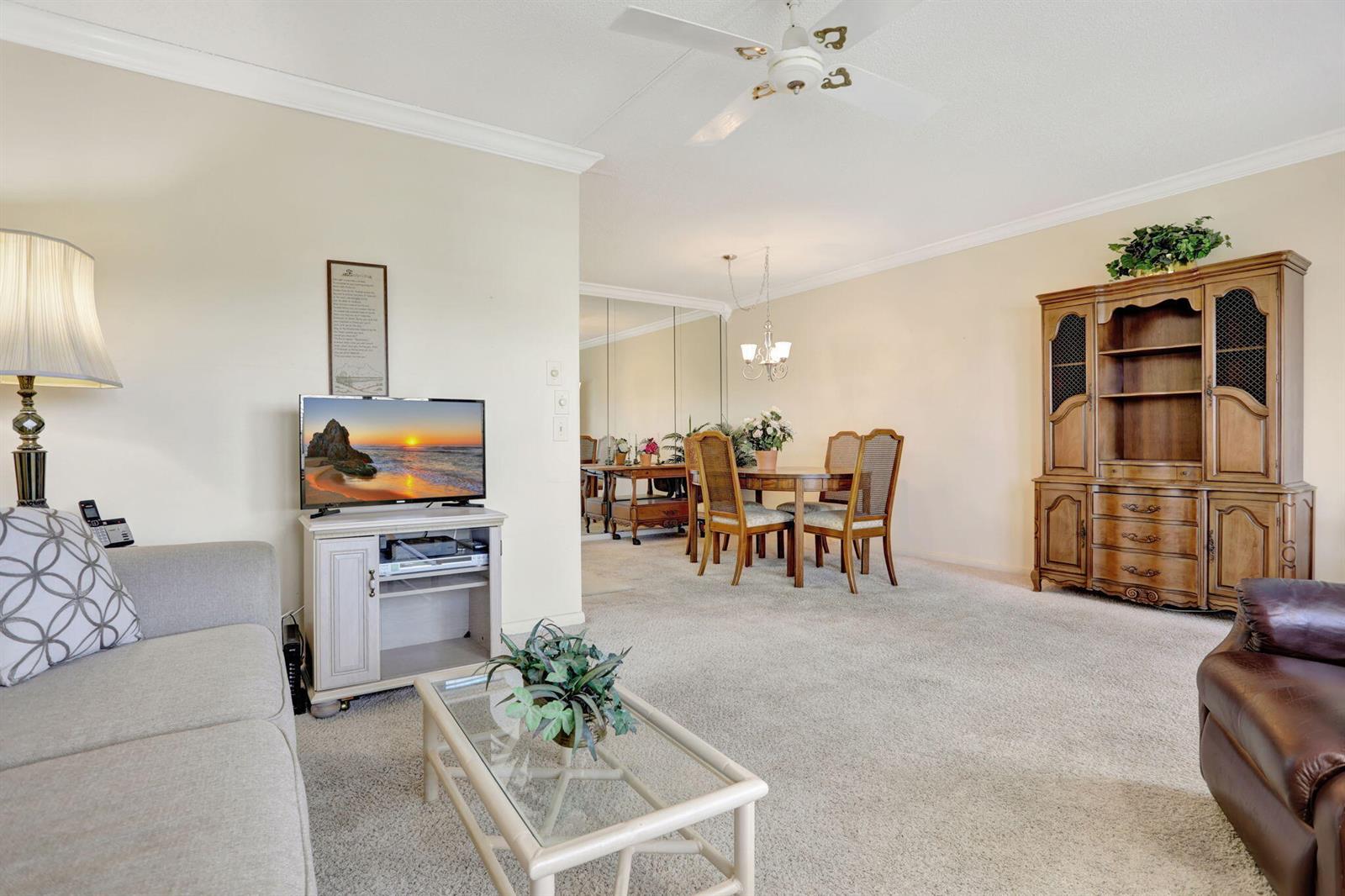 A living room with beige carpet, a dining area, and a large wooden hutch — 432 Grantham # B, Deerfield Beach FL 33442, DEERFIELD BEACH, FL
