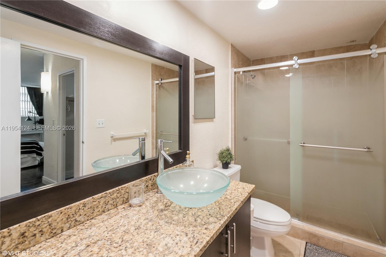 A bathroom features a granite vanity with a glass vessel sink and a glass shower — 4001 S Ocean Dr # 10B, Hollywood FL 33019, HOLLYWOOD, FL