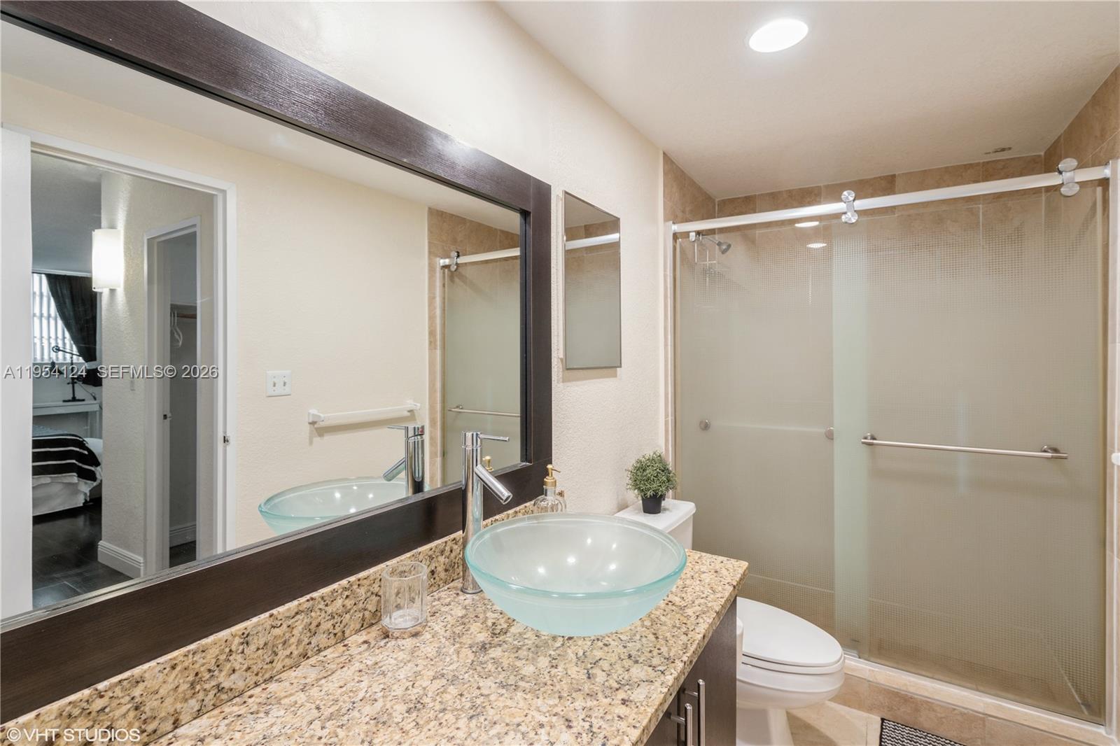 A bathroom features a granite countertop, a glass vessel sink, and a walk-in shower — 4001 S Ocean Dr # 10B, Hollywood FL 33019, HOLLYWOOD, FL