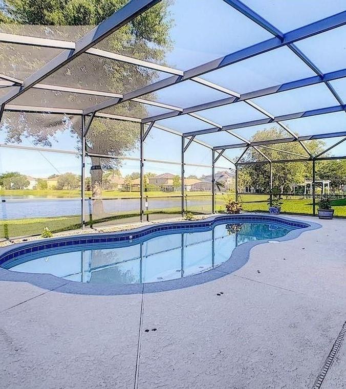 A two-story house with a light-colored stucco exterior, a single-car garage, and a palm tree — 12827 OULTON CIRCLE, ORLANDO, FL