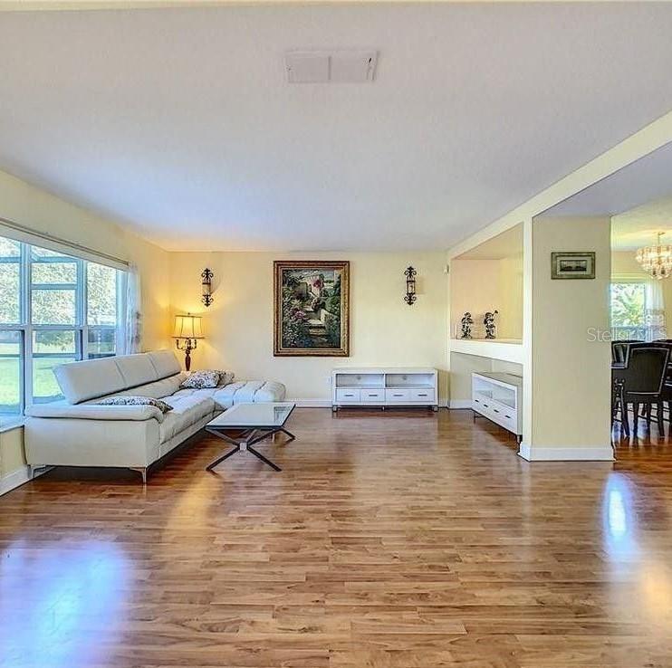 A screened-in swimming pool overlooks a lake behind a residential home — 12827 OULTON CIRCLE, ORLANDO, FL