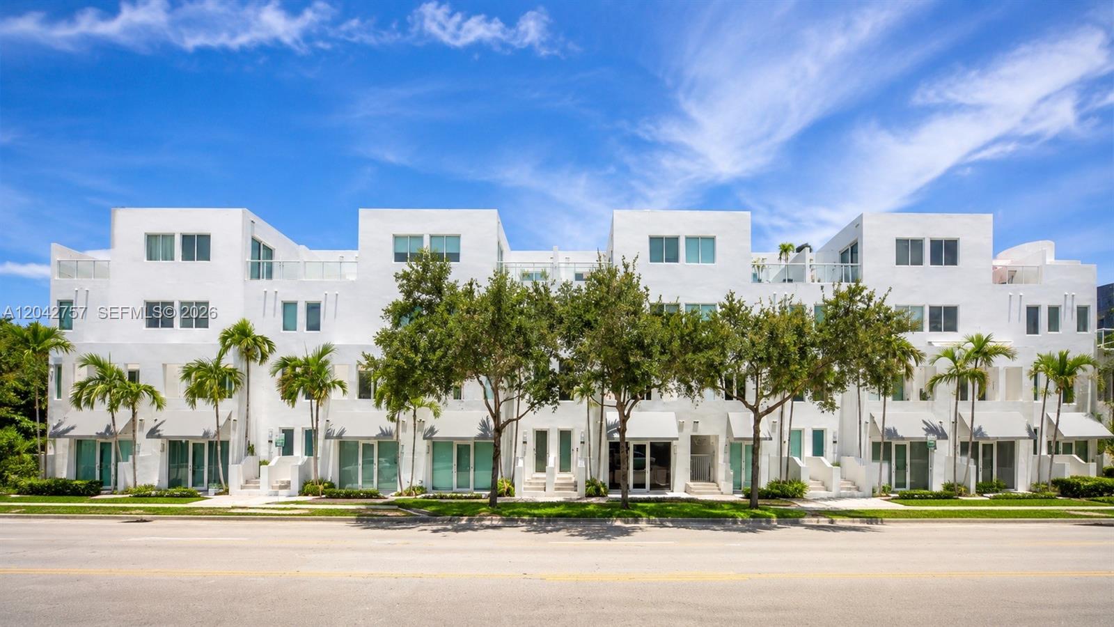 A multi-story white residential building features flat roofs, balconies, and palm trees in front — 710 NE 3rd Ave, Fort Lauderdale FL 33304, FORT LAUDERDALE, FL
