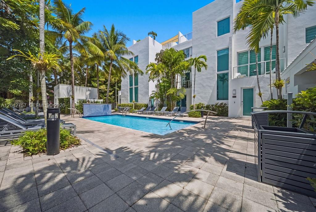 A rectangular swimming pool sits on a paved patio surrounded by palm trees and buildings — 710 NE 3rd Ave, Fort Lauderdale FL 33304, FORT LAUDERDALE, FL