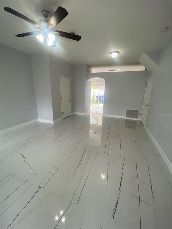 A room with light gray walls, white marble-patterned tile flooring, and a ceiling fan — 10103 BELLEVILLE PLACE, TAMPA, FL