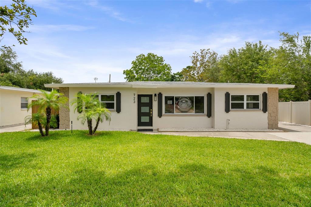 A single-story house with a white exterior, a black front door, and a green lawn — 723 W BAYSHORE DRIVE, TARPON SPRINGS, FL