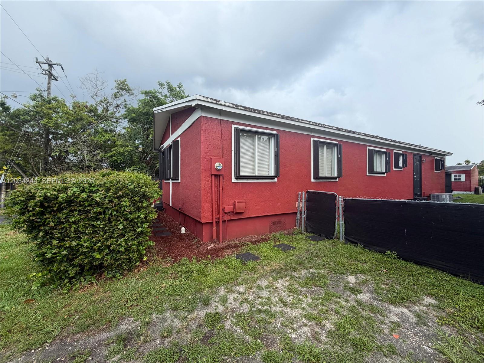 A red, single-story house with white trim and a black chain-link fence — 16980 SW 104th Ave, Miami FL 33157, MIAMI, FL