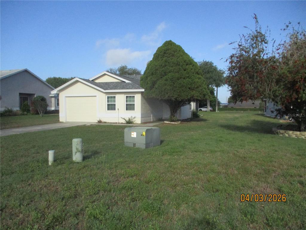 A single-story house with a garage and a large tree in the front yard — 6357 EGRET DRIVE, LAKELAND, FL