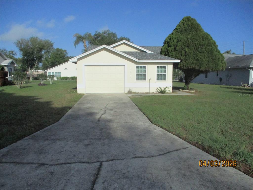 A single-story house with a beige exterior, a one-car garage, and a concrete driveway — 6357 EGRET DRIVE, LAKELAND, FL