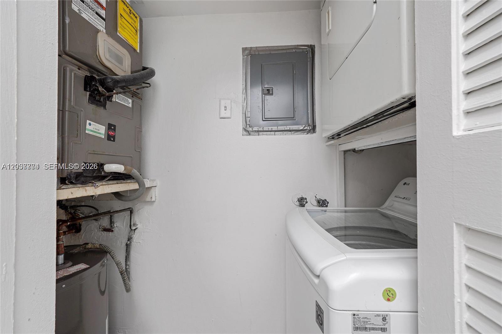 A utility closet contains a stacked washer and dryer, a water heater, and an HVAC unit — 200 Lakeview Dr # 101, Weston FL 33326, WESTON, FL