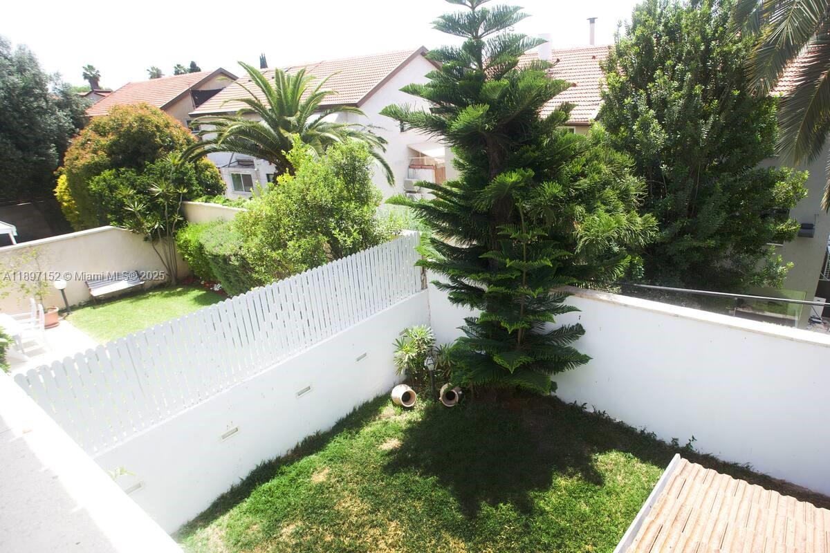 An elevated view of a private backyard featuring a lawn, a tall pine tree, and fencing — Hapiyyus 10, IL 4681400, IL