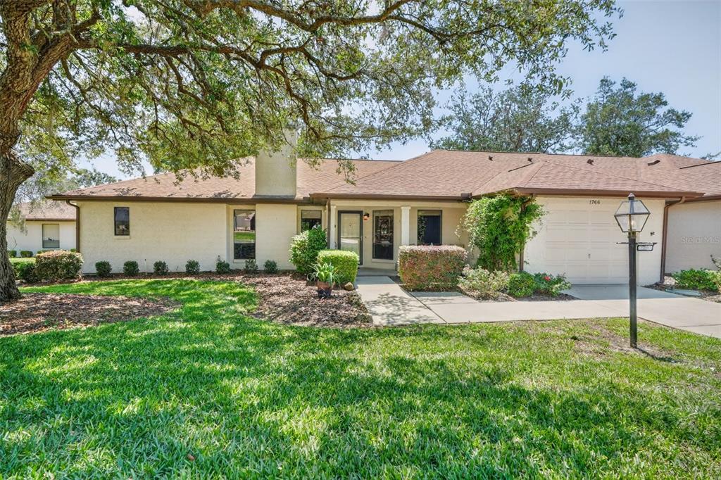 A single-story house with a tan stucco exterior, a brown shingled roof, and a garage — 1766 N ENSIGN POINT, CRYSTAL RIVER, FL