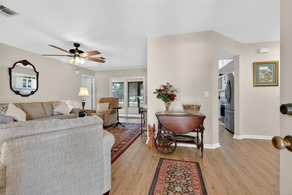 A living room features light wood flooring, a ceiling fan, and a wooden serving cart — 1766 N ENSIGN POINT, CRYSTAL RIVER, FL