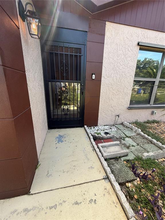 A front entryway features a black security screen door, a wall-mounted light, and a window — 5911 N FORK COURT, LAKELAND, FL