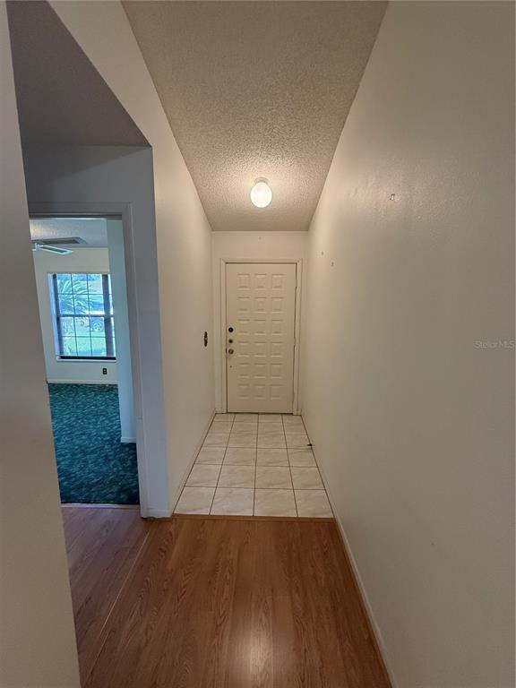 An entryway features a white front door, tiled floor, and wood-look laminate flooring — 5911 N FORK COURT, LAKELAND, FL