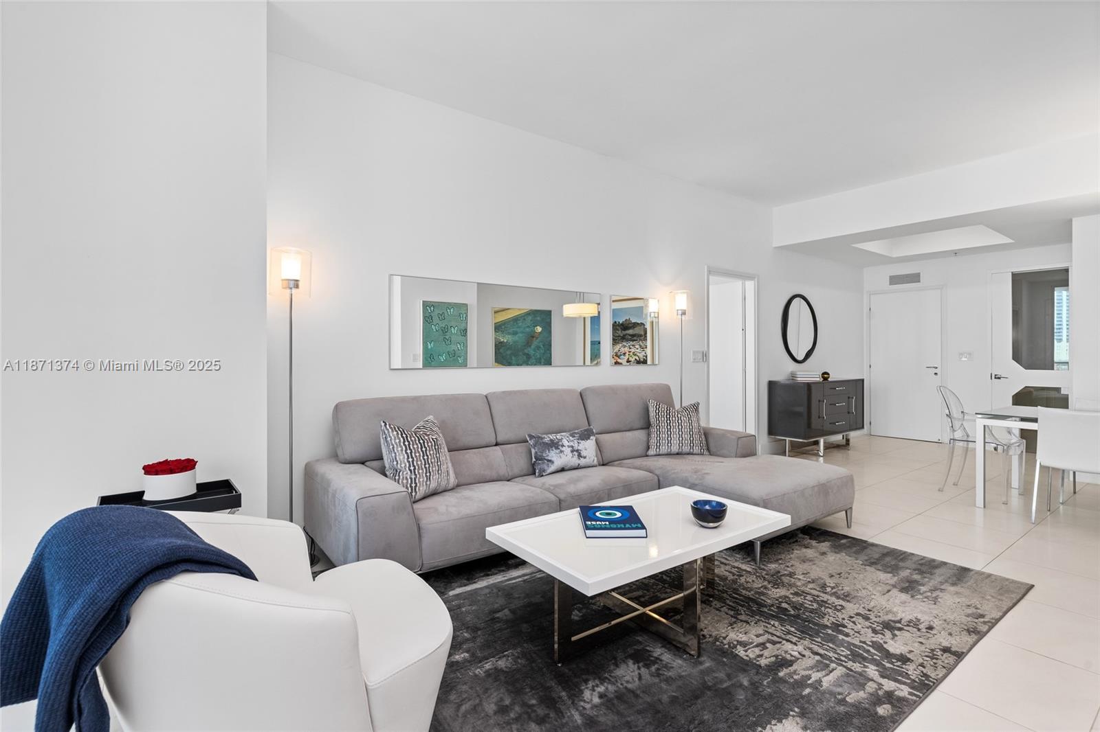 A modern living room features a gray sectional sofa, white coffee table, and area rug — 50 S Pointe Dr # 1005, Miami Beach FL 33139, MIAMI BEACH, FL