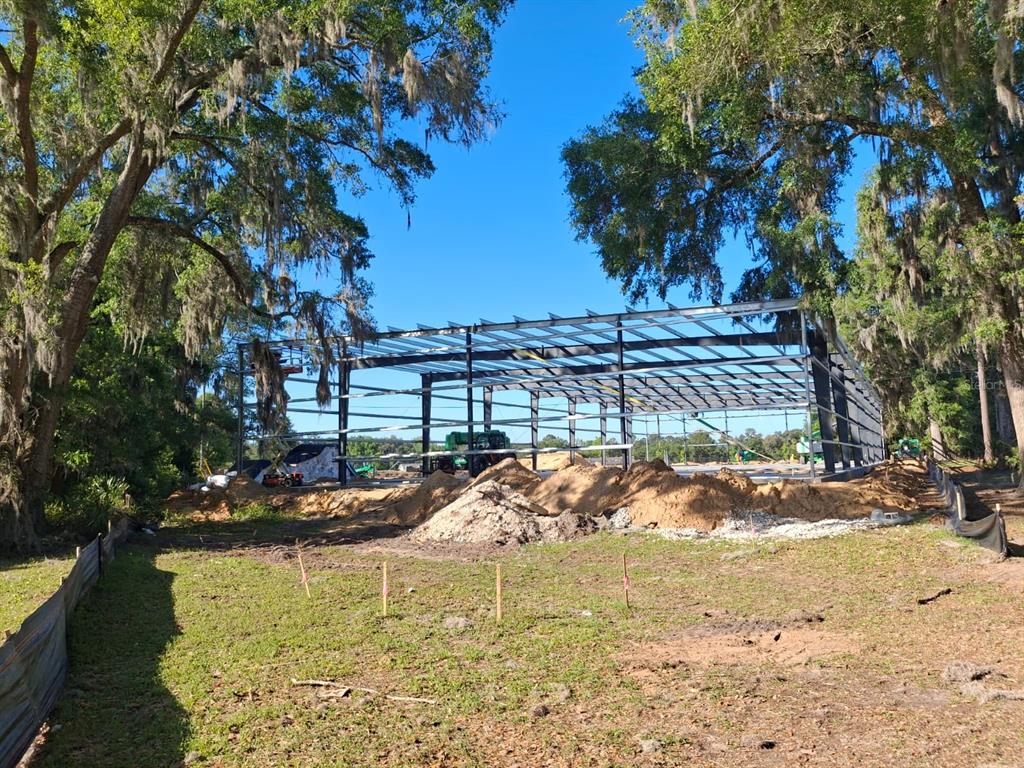 A steel frame structure for a building under construction sits on a cleared, sandy lot — 12142 SE COUNTY 484 HIGHWAY, BELLEVIEW, FL